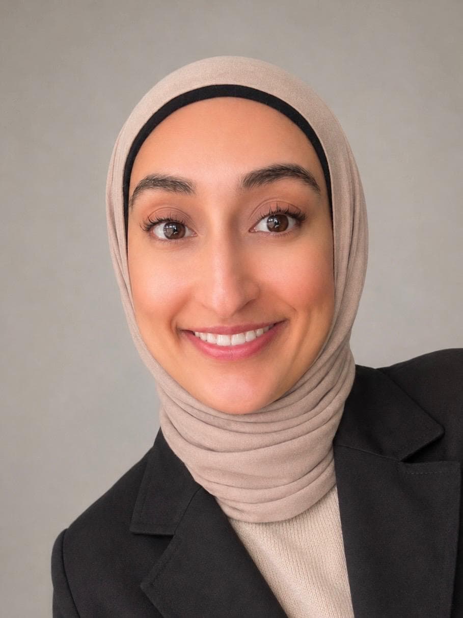 Raabia Hussain, smiling, in a dark blazer